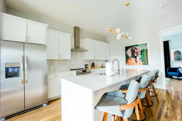 a kitchen with stainless steel appliances granite countertop a sink a stove and refrigerator