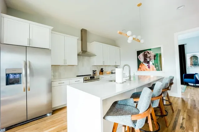 a kitchen with stainless steel appliances granite countertop a sink a stove and refrigerator