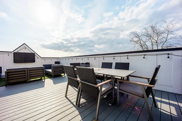 a view of a roof deck with wooden floor and outdoor seating