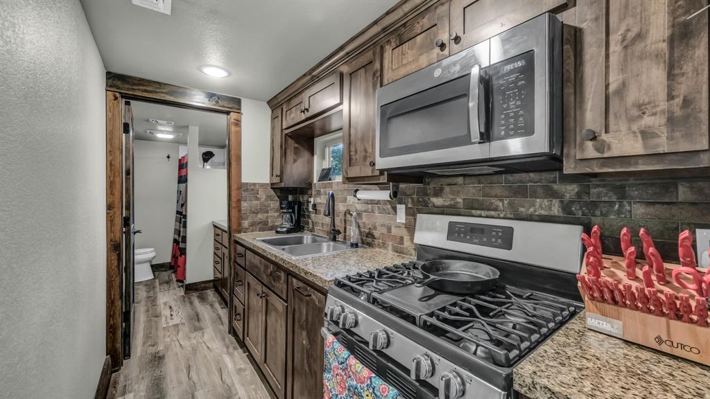 1140 Garvey Ranch Road Loving, TX 76460 - Photo 9 of 40 a kitchen with stainless steel appliances granite countertop a stove and a sink