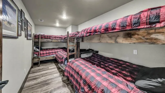 a bedroom with a bed a mirror on the wall and a large window