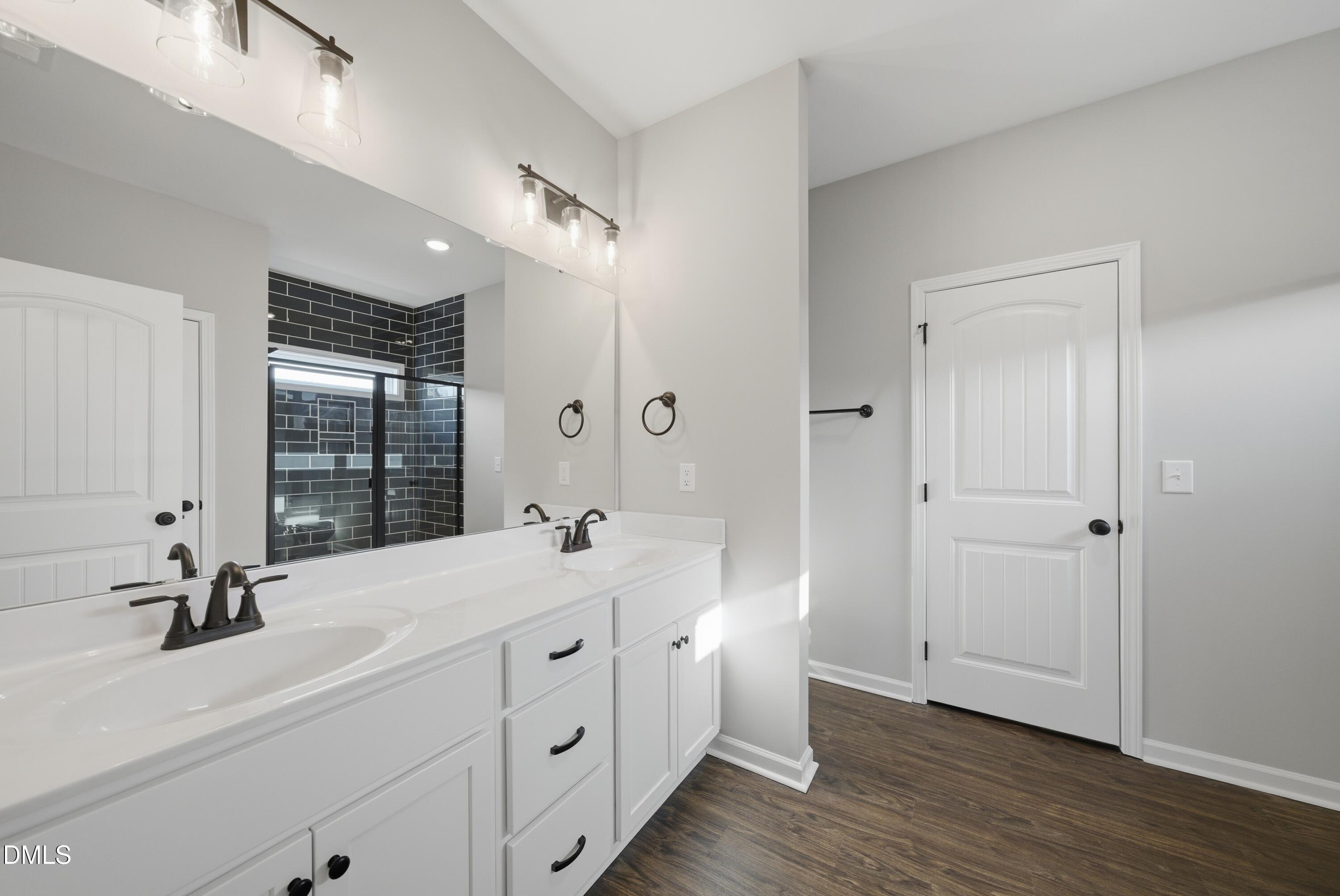 9315 Turkey Way Middlesex, NC 27557 - Photo 14 of 34 a bathroom with a double vanity sink a mirror and next to a window