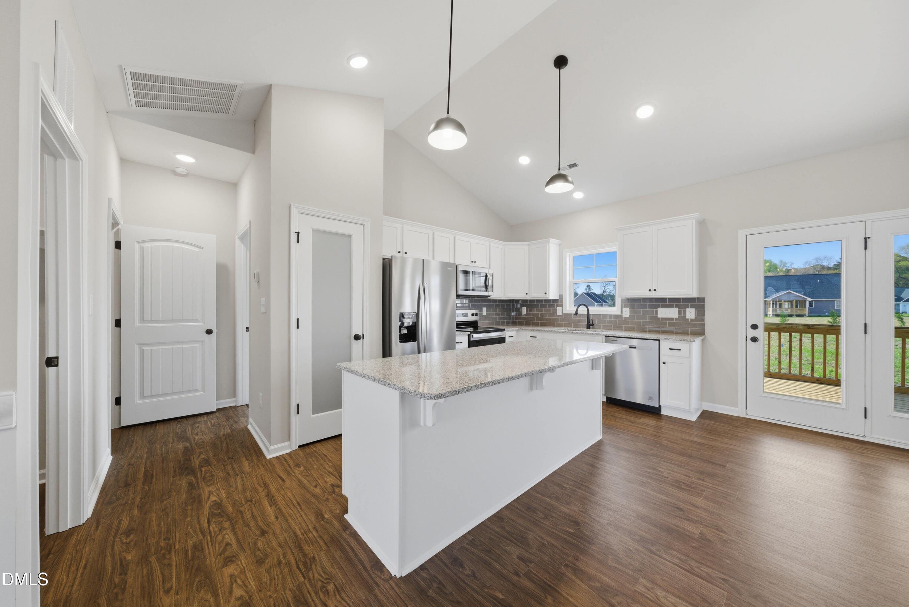 9315 Turkey Way Middlesex, NC 27557 - Photo 2 of 34 a kitchen with stainless steel appliances kitchen island a refrigerator a stove and white cabinets with wooden floor