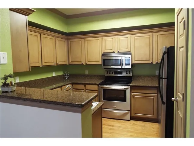 a kitchen with kitchen island a sink stainless steel appliances and cabinets