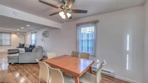 a living room with furniture a chandelier fan and a window