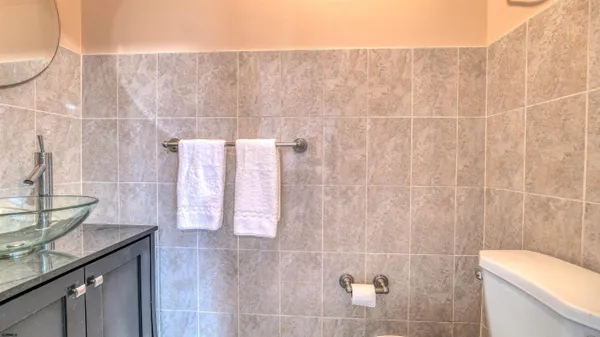 a bathroom with a granite countertop sink a toilet and mirror