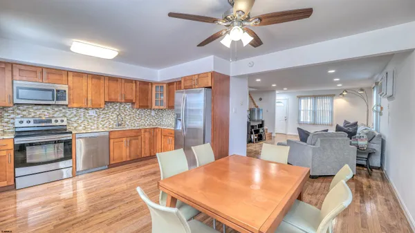 a large kitchen with a table chairs refrigerator and cabinets