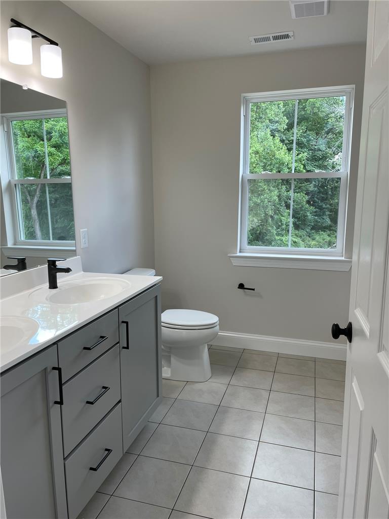 5043 Chapmans Road Orefield, PA 18069 - Photo 12 of 30 Dual vanity and light tile flooring create a functional and pleasant bathroom environment.
