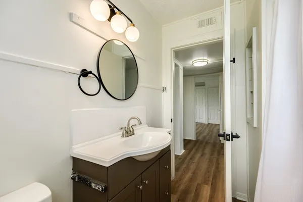 a bathroom with a sink and mirror with toilet