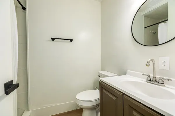 a bathroom with a granite countertop toilet sink and mirror