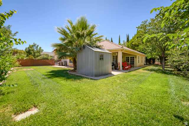 3034 Swiss Drive Santa Clara, UT 84765 - Photo 8 of 59 Expansive rear yard featuring a manicured lawn, established trees, and a detached storage shed