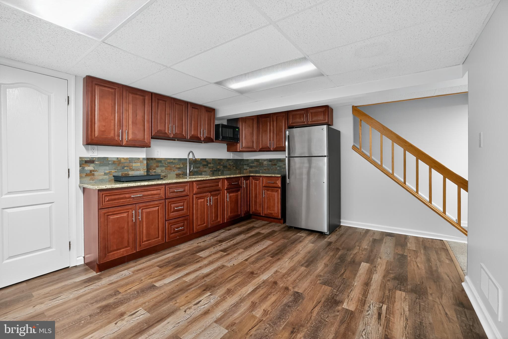 301 Windy Run Road Doylestown, PA 18901 - Photo 37 of 51 a kitchen with granite countertop wooden floors a stove and a refrigerator