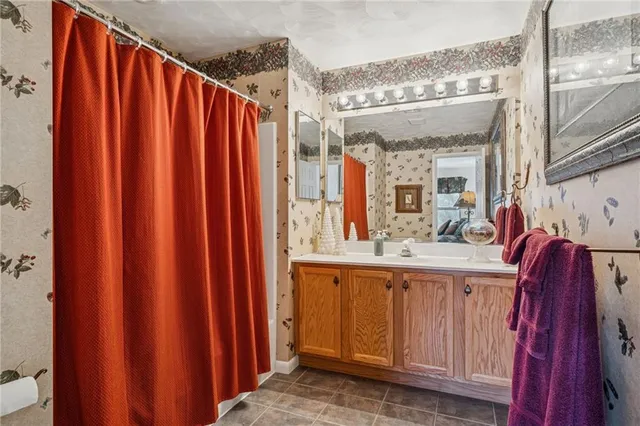 a bathroom with a sink a mirror and shower curtain