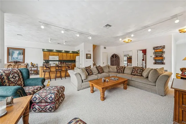 a living room with furniture kitchen view and a table
