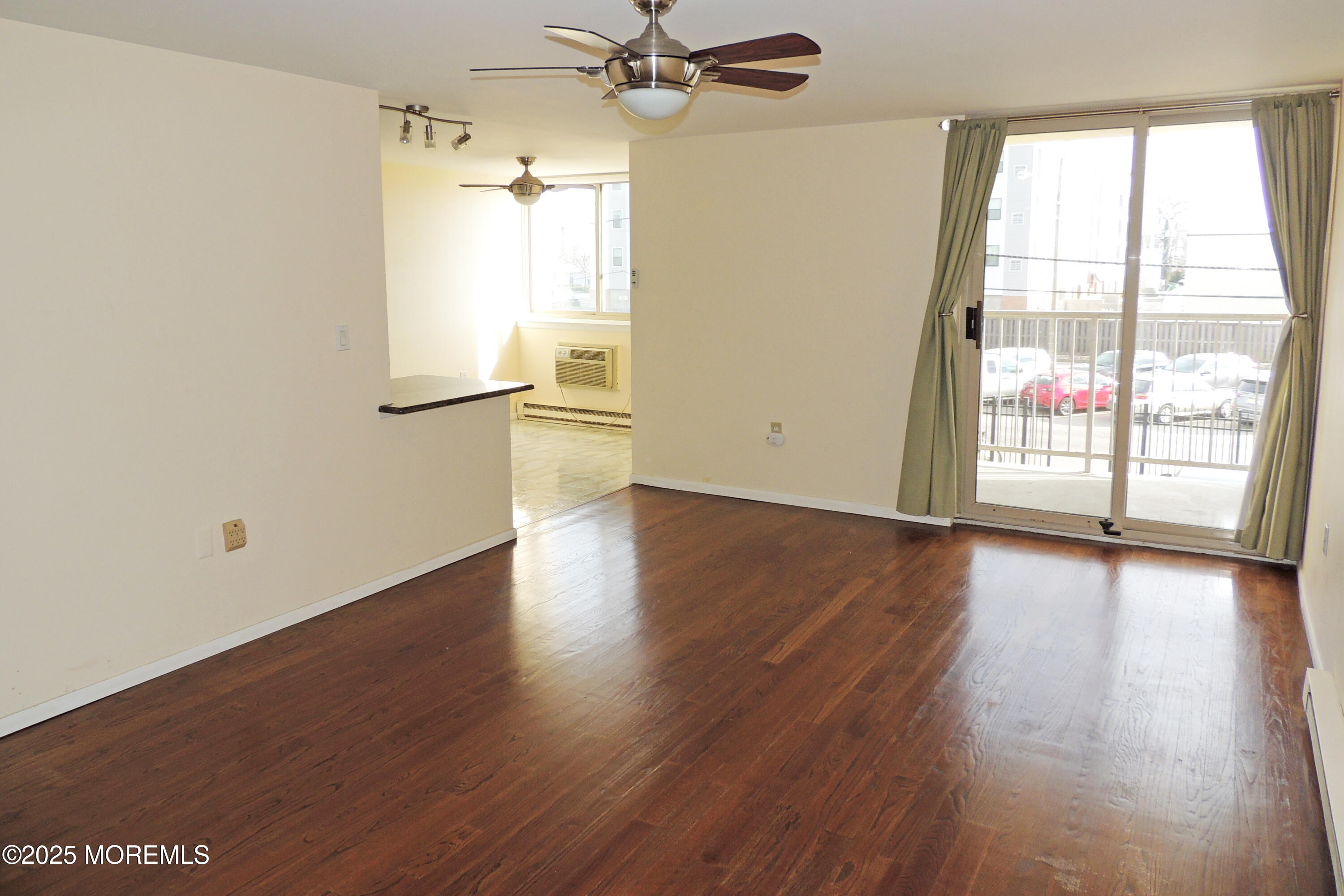 1000 River Road, Unit 2K Belmar, NJ 07719 - Photo 11 of 25 an empty room with wooden floor fan and windows