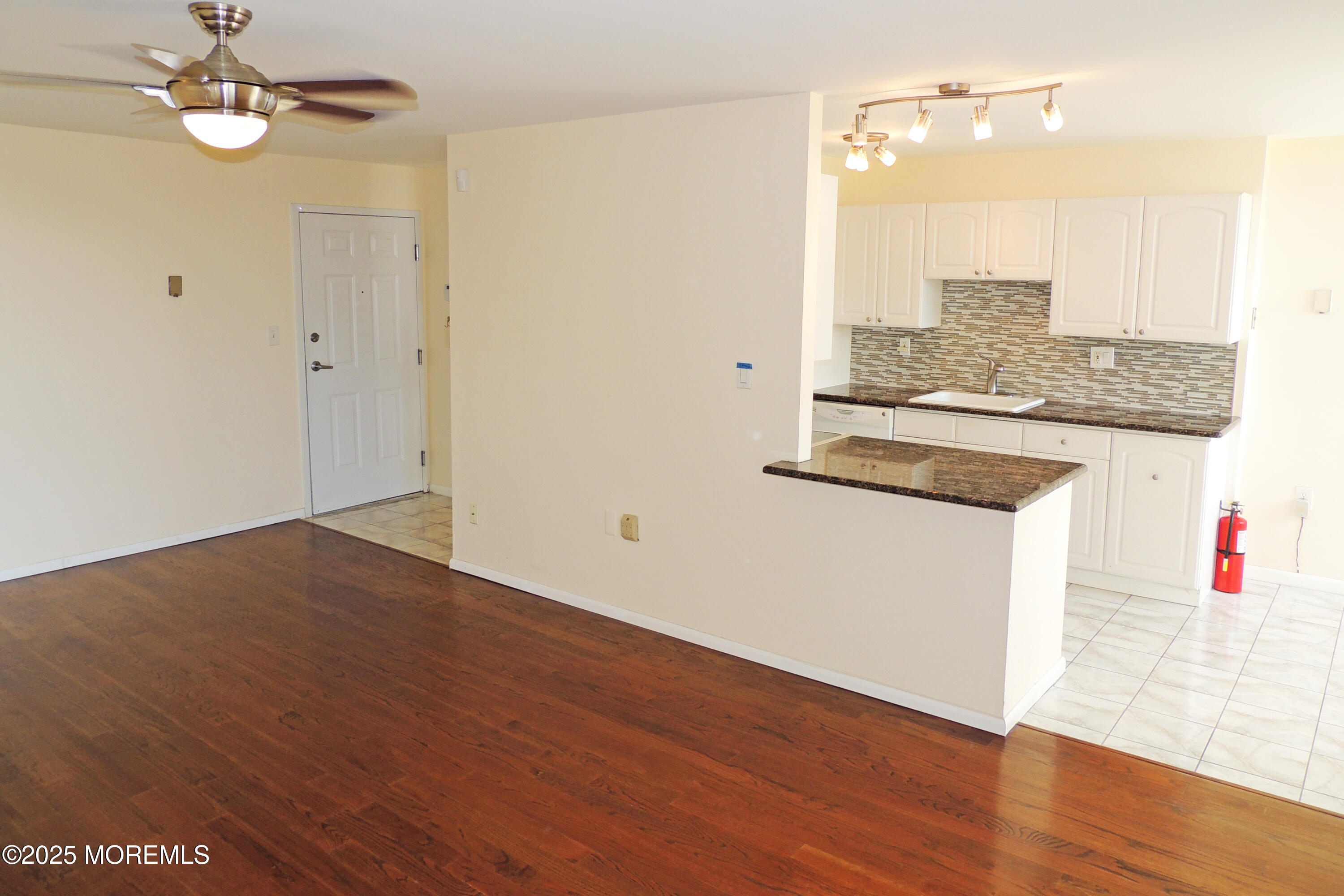 1000 River Road, Unit 2K Belmar, NJ 07719 - Photo 14 of 25 an empty room with wooden floor and ceiling fan