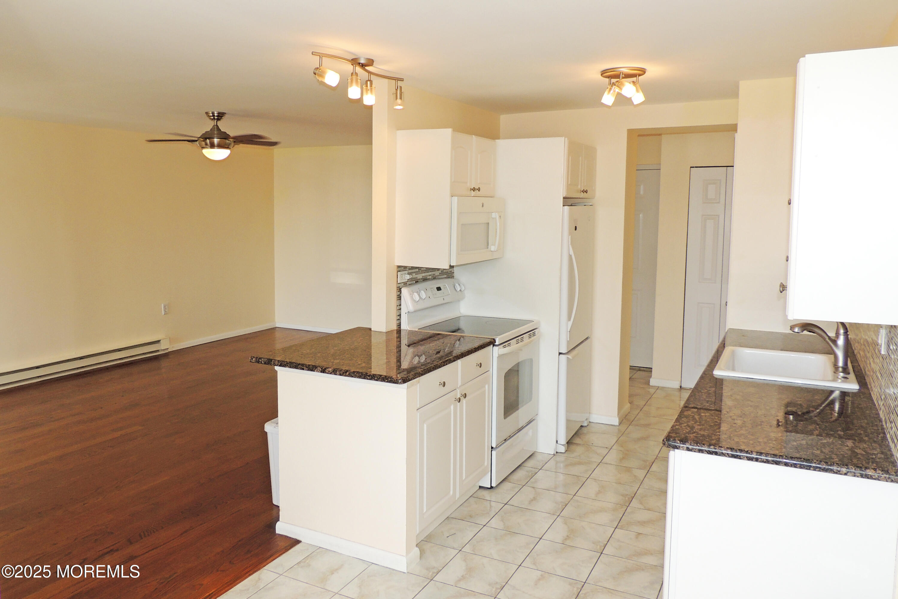 1000 River Road, Unit 2K Belmar, NJ 07719 - Photo 19 of 25 a kitchen with granite countertop a sink and a refrigerator