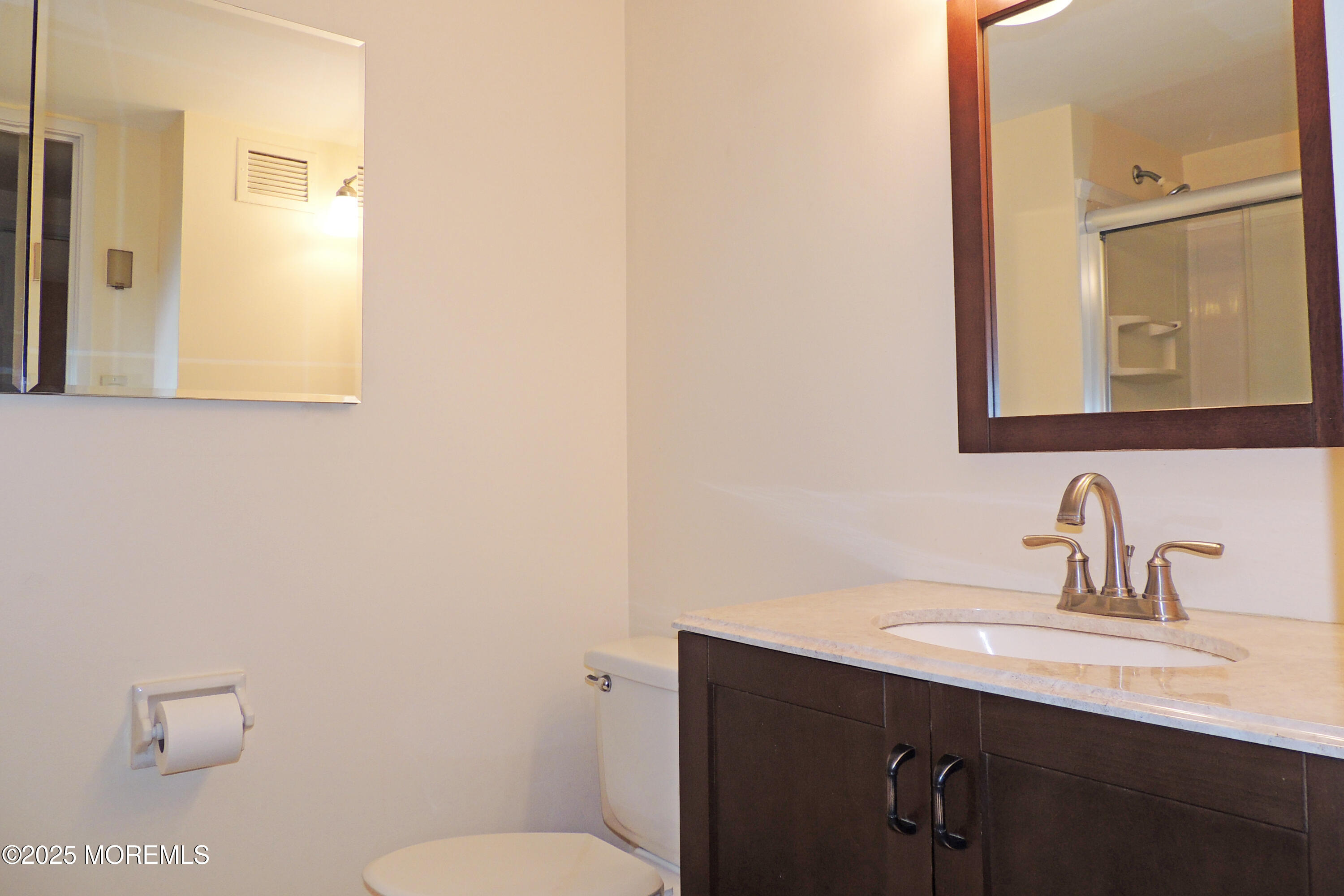 1000 River Road, Unit 2K Belmar, NJ 07719 - Photo 6 of 25 a bathroom with a toilet a sink and mirror