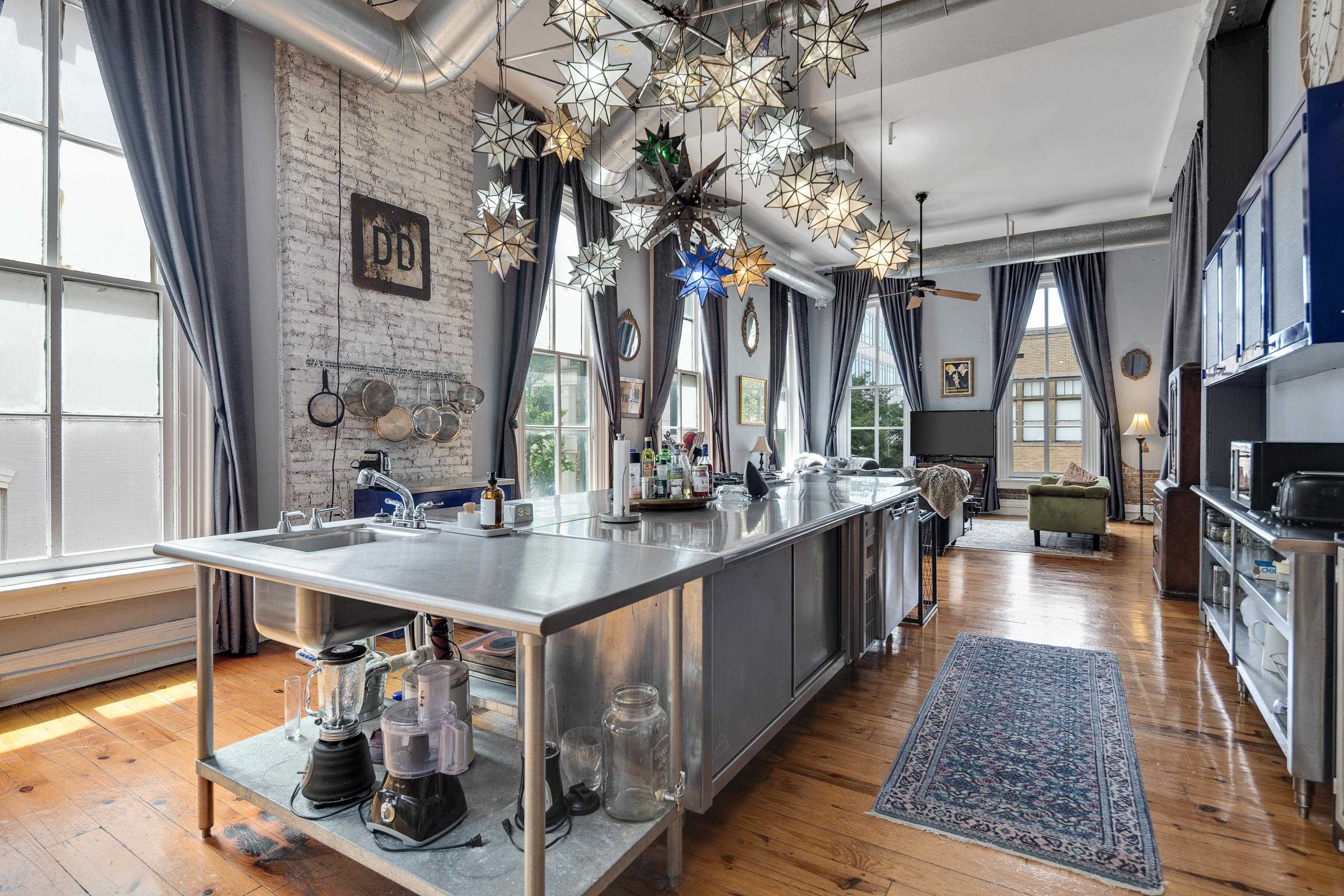 116 South Front Street, Unit 201 Memphis, TN 38103 - Photo 9 of 26 Kitchen with a spacious island, hardwood / wood-style floors, black microwave, and hanging light fixtures