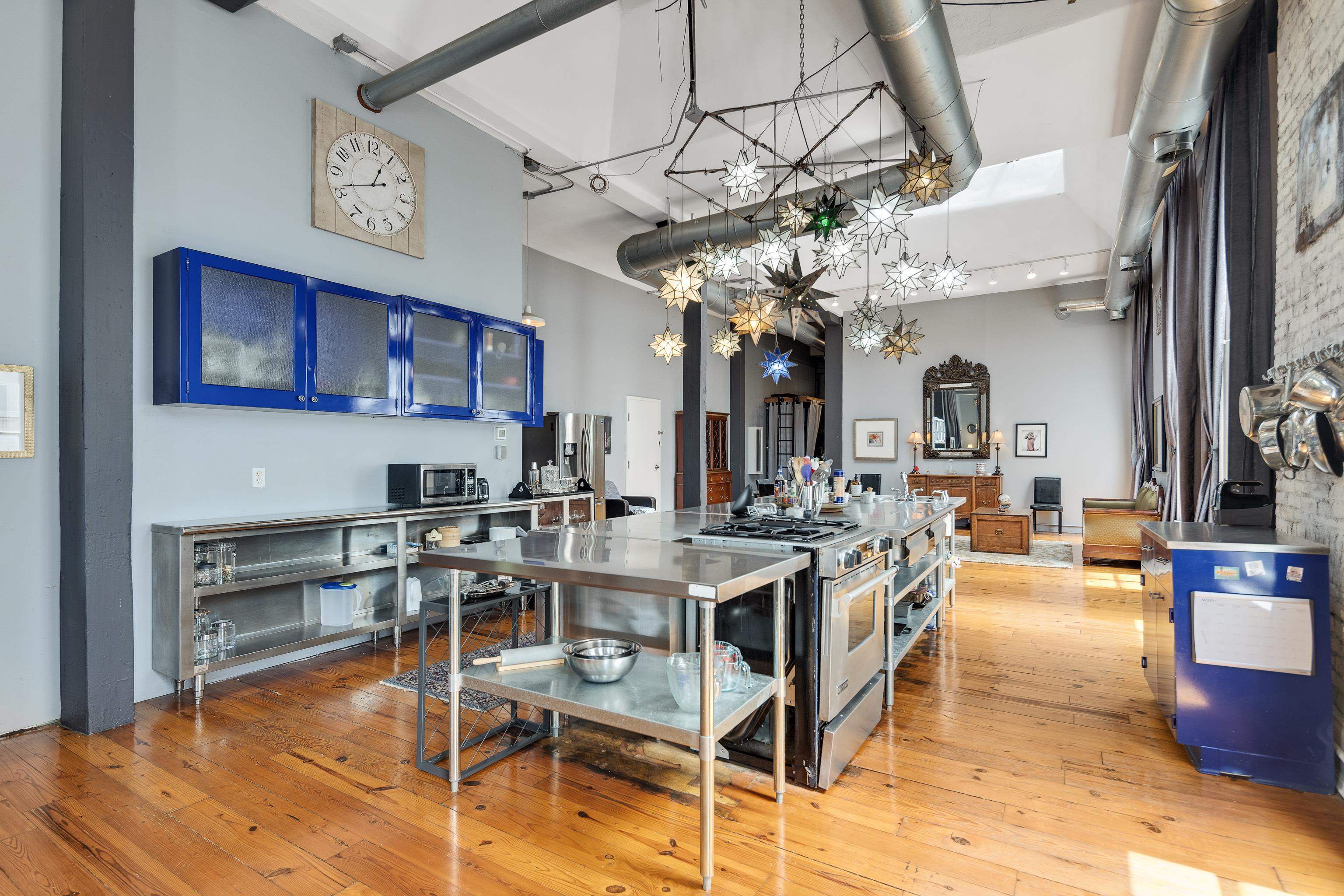 116 South Front Street, Unit 201 Memphis, TN 38103 - Photo 10 of 26 Kitchen featuring a high ceiling, light wood-style floors, stainless steel range with gas stovetop, glass fronted cabinets, and stainless steel counters