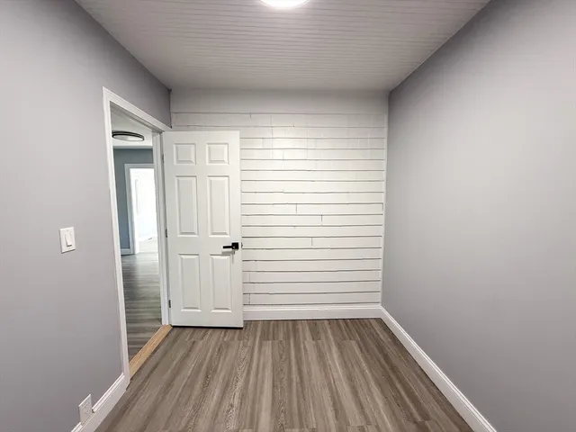 a view of a room with wooden floor and white walls