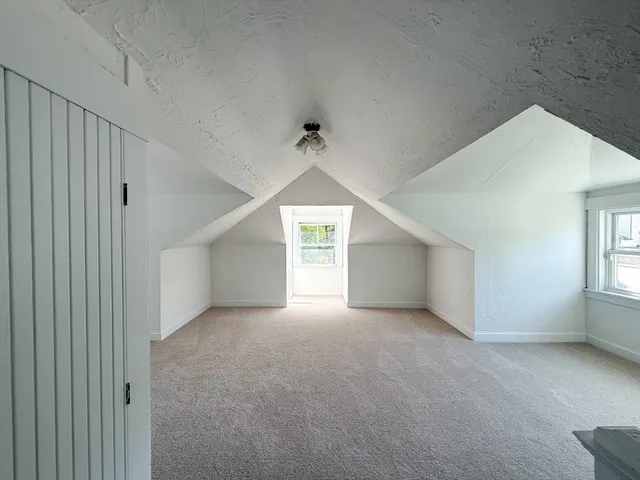 en empty room with windows and ceiling fan