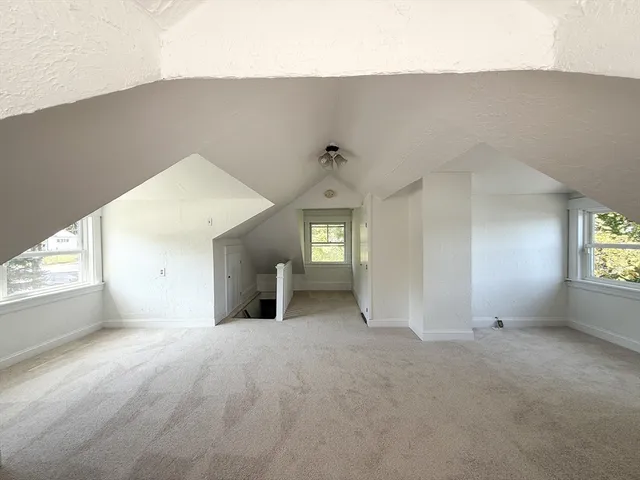 a view of a big room with windows and chandelier fan