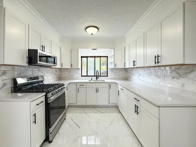 a kitchen with granite countertop white cabinets and white appliances