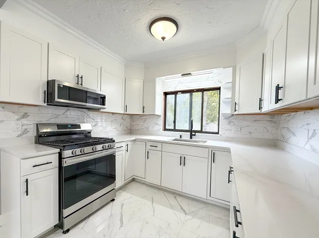 a kitchen with cabinets appliances and a window