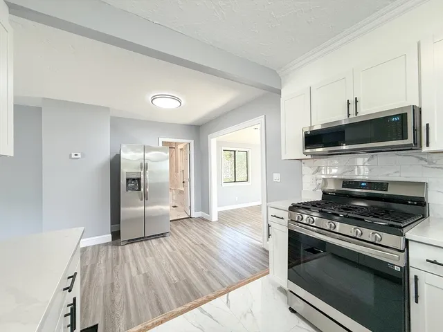 a kitchen with granite countertop a stove and a wooden floor
