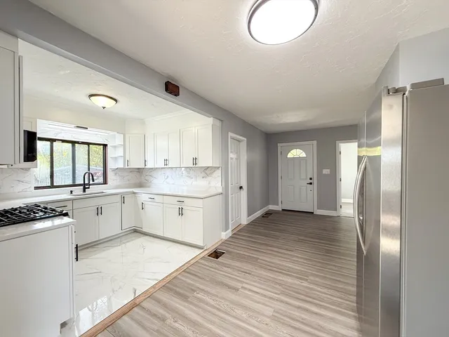a kitchen with cabinets and wooden floor