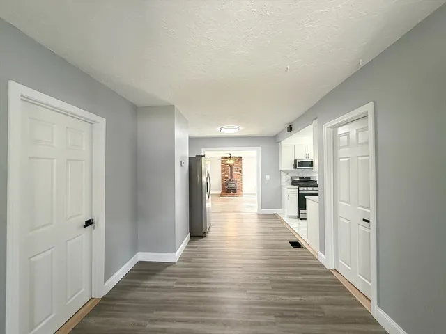 a view of a hallway with wooden floor and closet