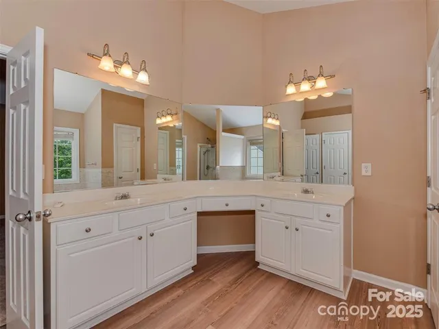 a spacious bathroom with a granite countertop sink a large mirror and a vanity