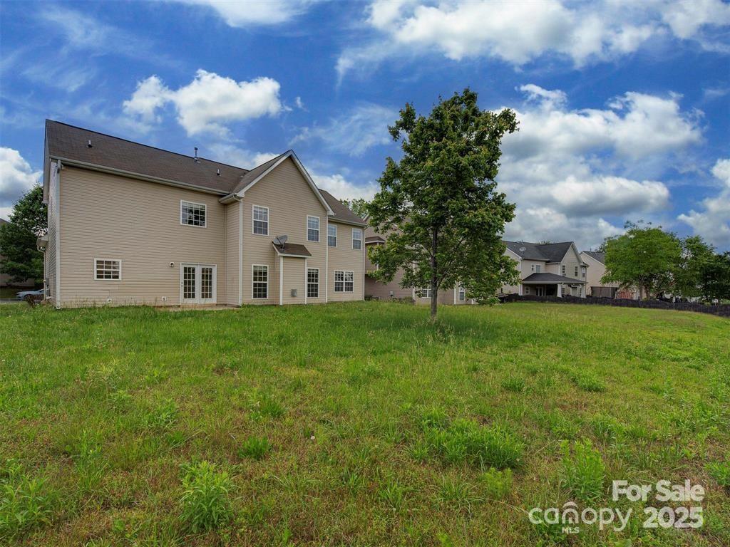5607 Fulton Ridge Drive Indian Trail, NC 28079 - Photo 39 of 45 a view of a white house next to a yard with big trees