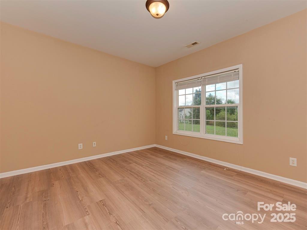 5607 Fulton Ridge Drive Indian Trail, NC 28079 - Photo 8 of 45 a view of an empty room with wooden floor and a window