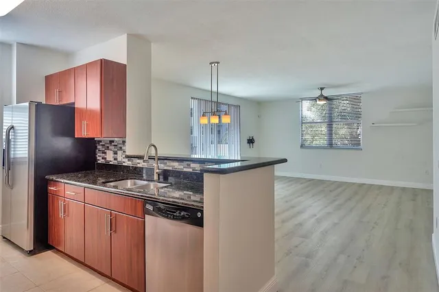 a kitchen with stainless steel appliances granite countertop wooden cabinets stove and granite counter top