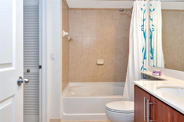 an empty room with wooden floor chandelier fan and windows