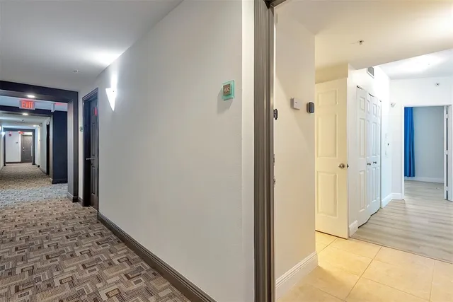 a view of a hallway with a door and wooden door