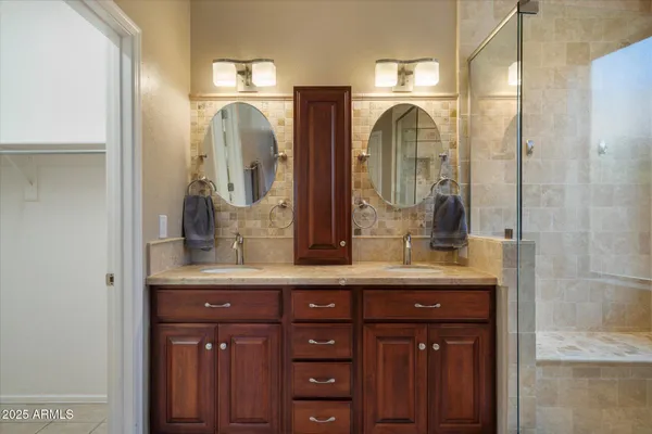 a bathroom with mirror two sinks a vanity and a large mirror