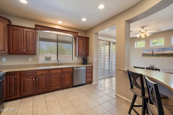 a large kitchen with kitchen island granite countertop a table chairs sink and cabinets