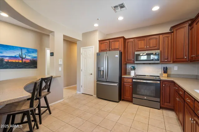 a kitchen with stainless steel appliances granite countertop a refrigerator and a stove top oven