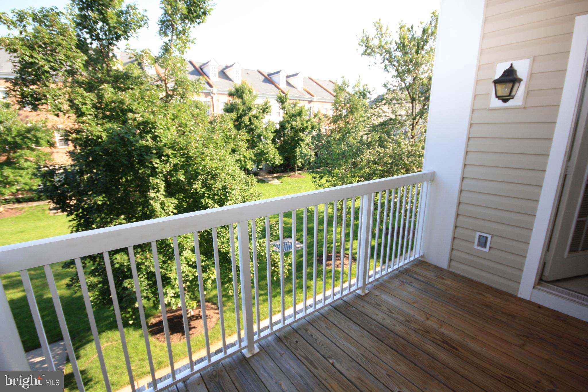 22691 Blue Elder Terrace, Unit 204 Brambleton, VA 20148 - Photo 19 of 45 a view of a balcony with wooden floor