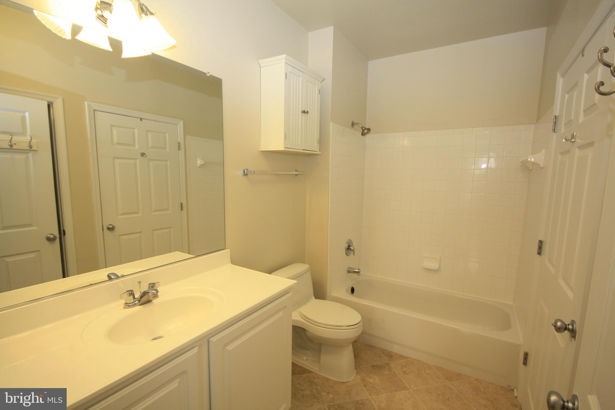 22691 Blue Elder Terrace, Unit 204 Brambleton, VA 20148 - Photo 21 of 45 a bathroom with a sink a toilet and shower