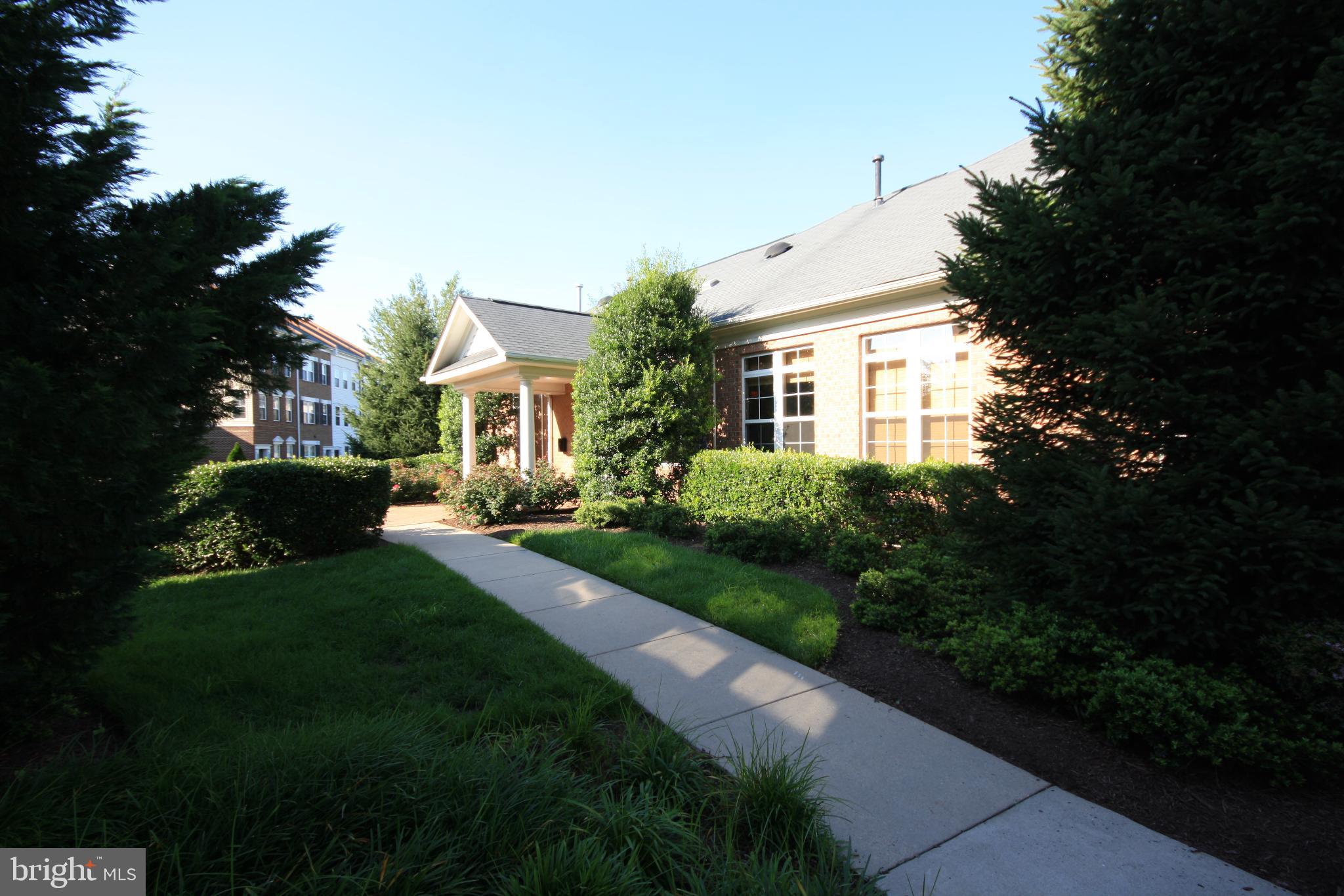 22691 Blue Elder Terrace, Unit 204 Brambleton, VA 20148 - Photo 23 of 45 a front view of a house with a garden