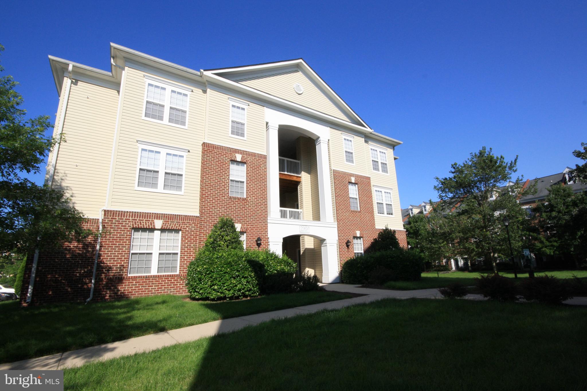 22691 Blue Elder Terrace, Unit 204 Brambleton, VA 20148 - Photo 3 of 45 a front view of a house with a yard