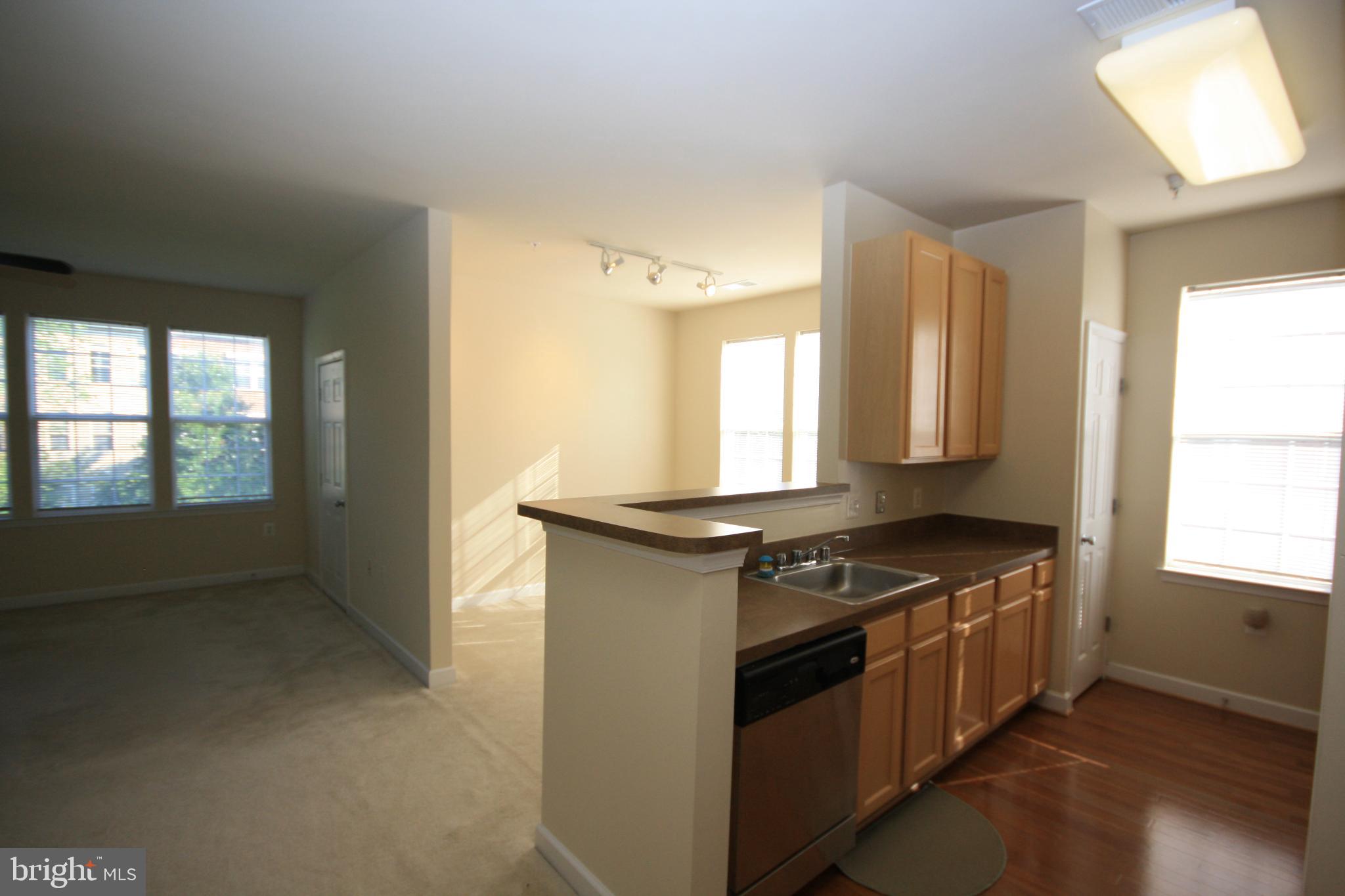 22691 Blue Elder Terrace, Unit 204 Brambleton, VA 20148 - Photo 8 of 45 a kitchen with stainless steel appliances granite countertop a stove and a sink