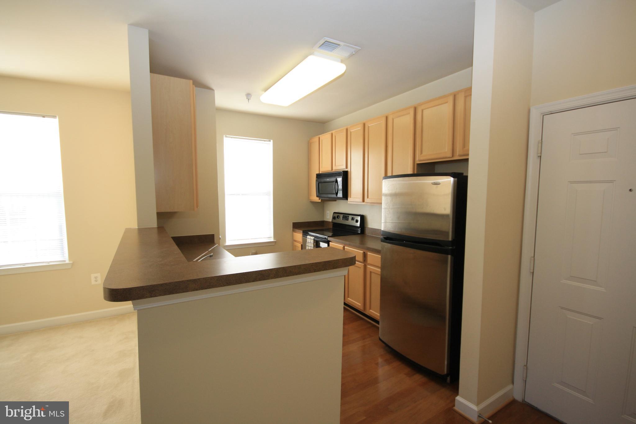 22691 Blue Elder Terrace, Unit 204 Brambleton, VA 20148 - Photo 10 of 45 a kitchen with stainless steel appliances a refrigerator sink and microwave