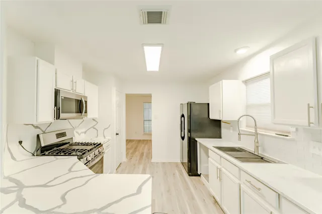 a kitchen with a stove a sink and a refrigerator