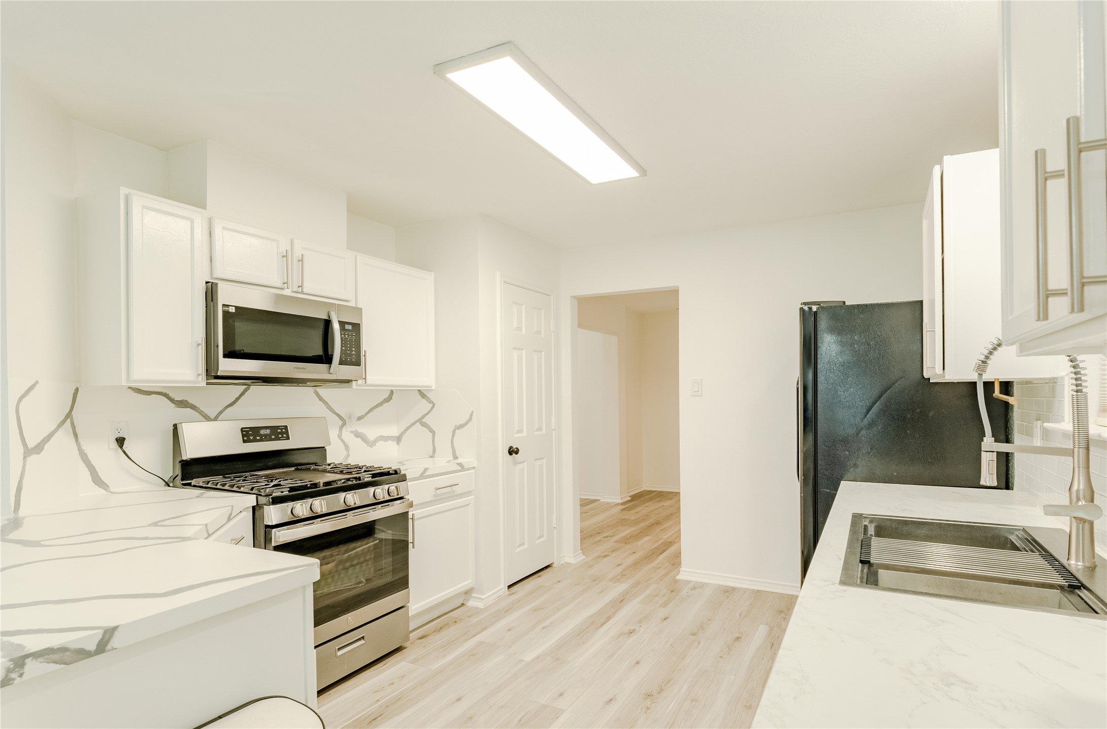 9203 Appin Court Houston, TX 77095 - Photo 2 of 38 a kitchen with stainless steel appliances a stove a microwave and a sink