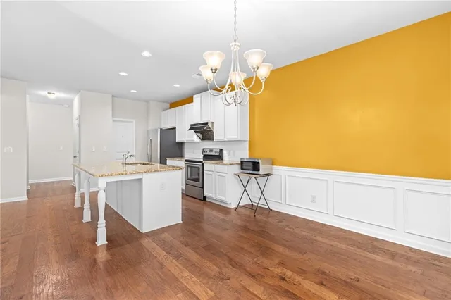 a kitchen with a sink cabinets and wooden floor